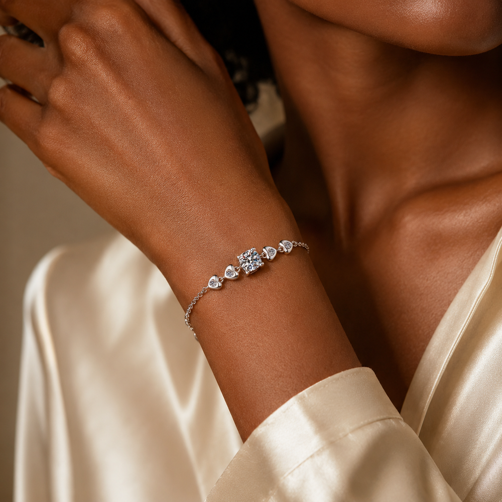Woman wearing Amoura moissanite heart bracelet with champagne satin