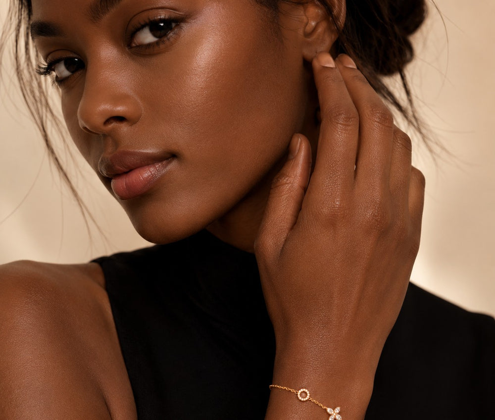 Delicate gold clover moissanite bracelet worn with black attire