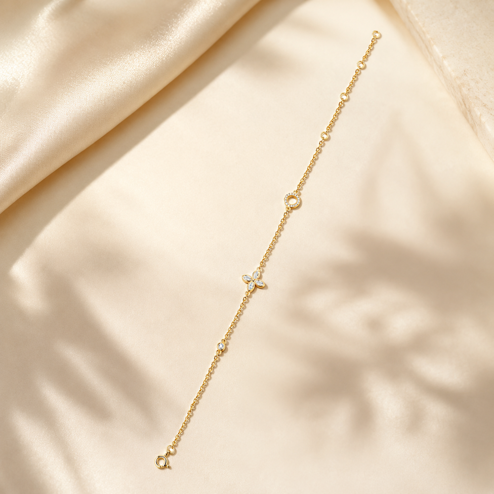 Full view of adjustable gold moissanite clover bracelet on ivory satin