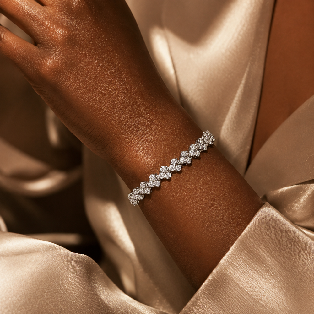 Woman wearing silver moissanite floral cluster bracelet with champagne satin