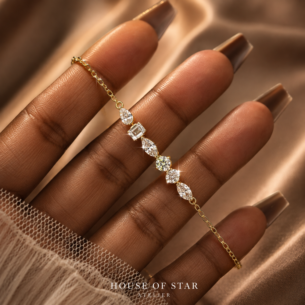 Yellow gold-tone adjustable moissanite station bracelet held in hand