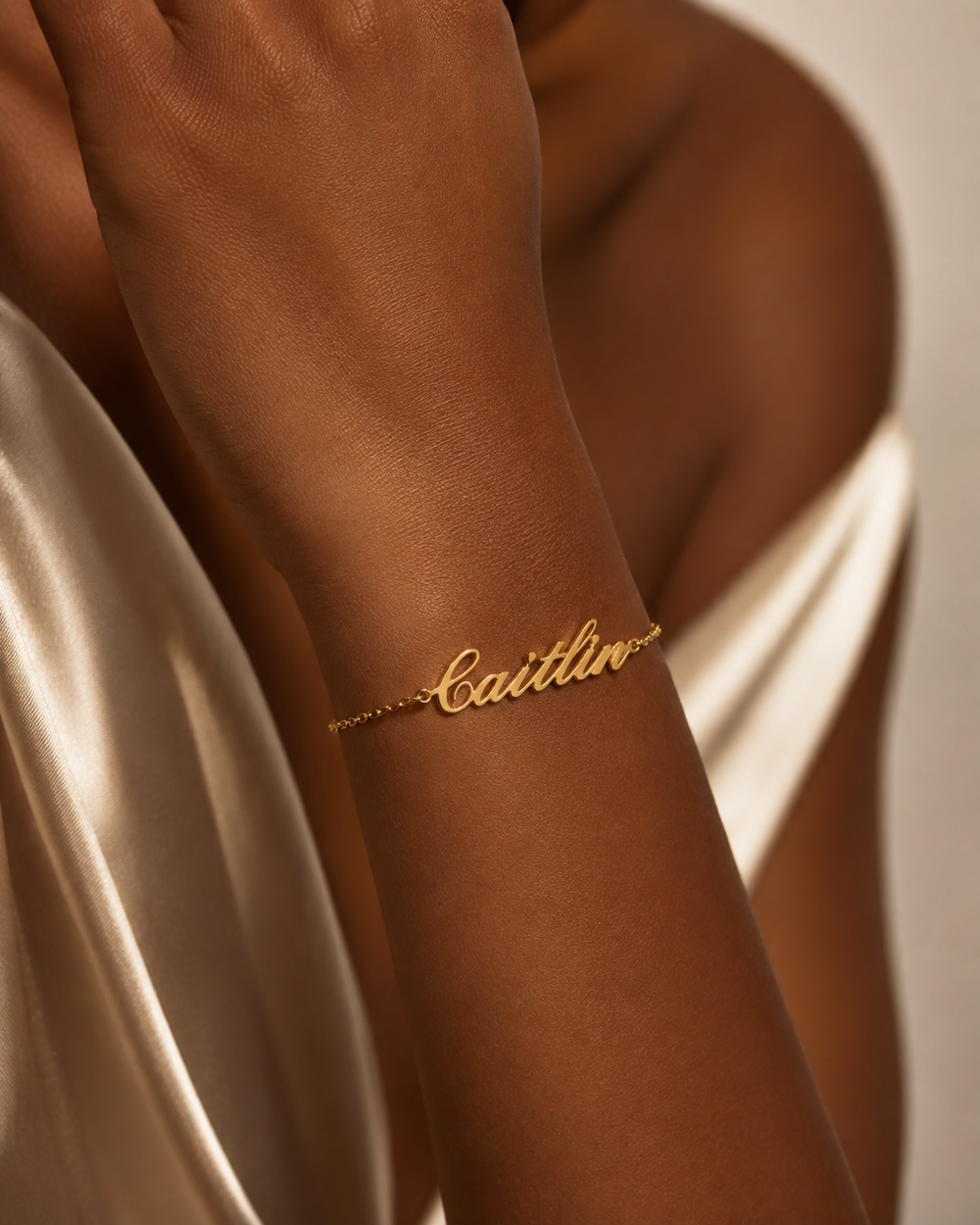 Black woman wearing a custom gold script name bracelet