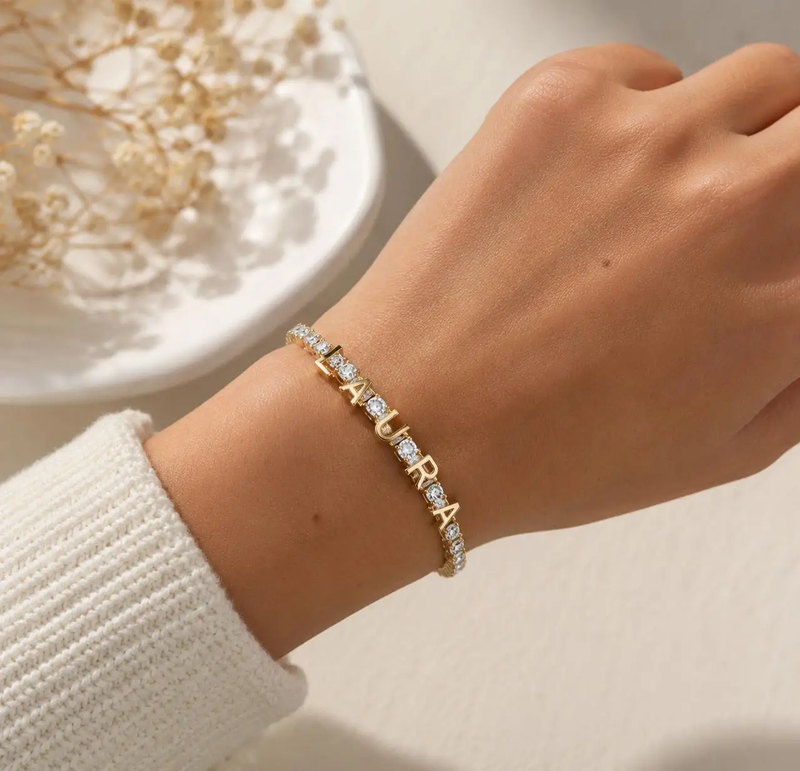 Close-up of gold custom-name tennis bracelet on wrist